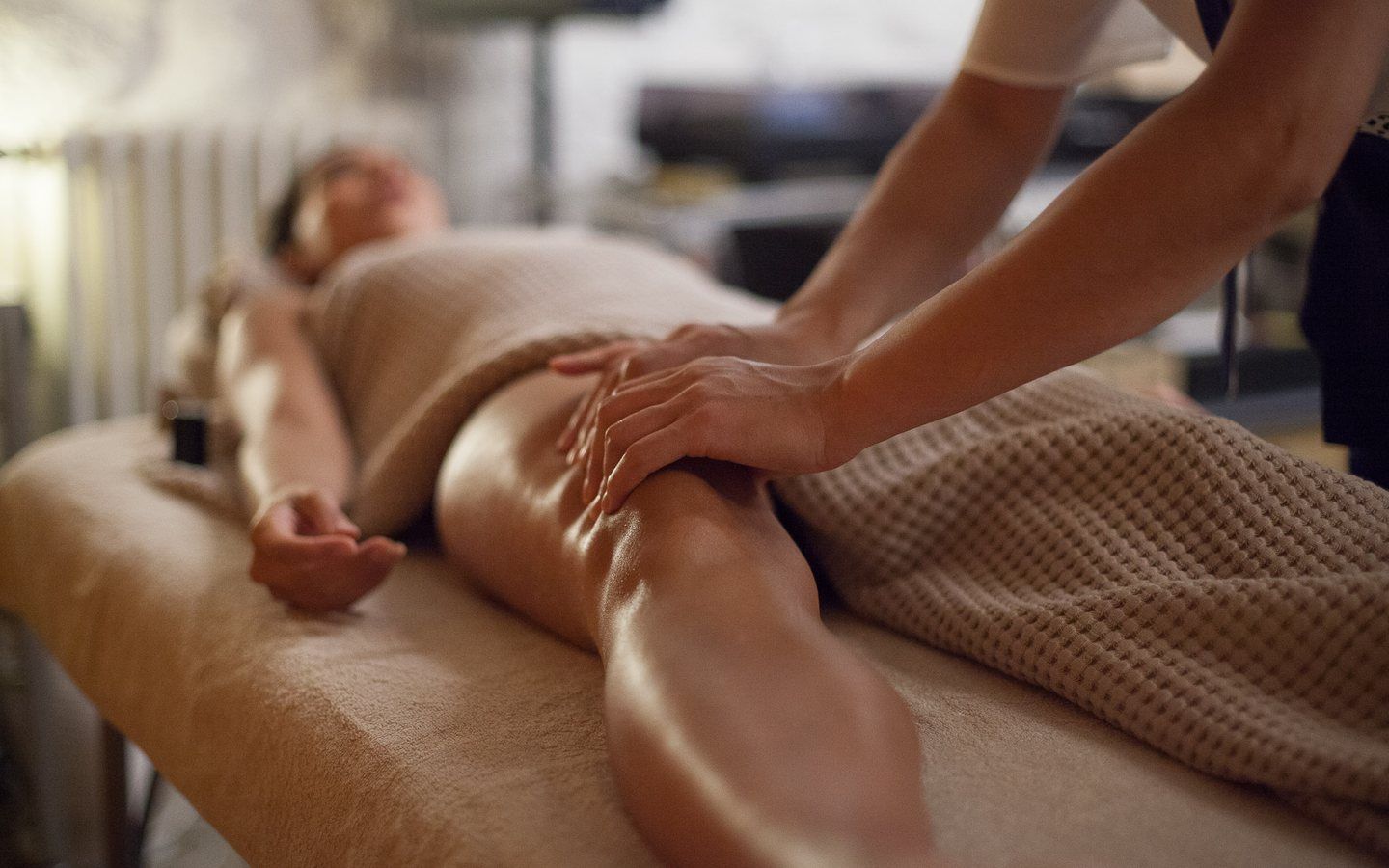 Drainage lymphatique des jambes, cliente allongée sous un linge gaufré